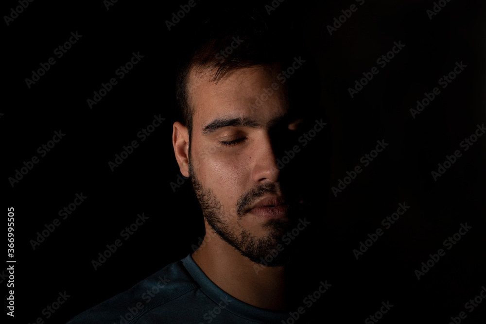 Selective focus portrait of young caucasian man on a black background