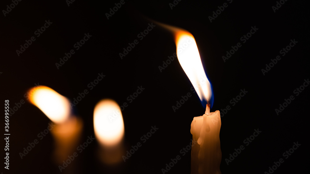 Close-up shots of yellow candles and lights on a black background with bokeh lights Close-up shots of yellow candles and lights on a black background with bokeh lights