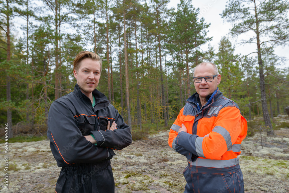 Portrait of mature man and young man together standing in the forest