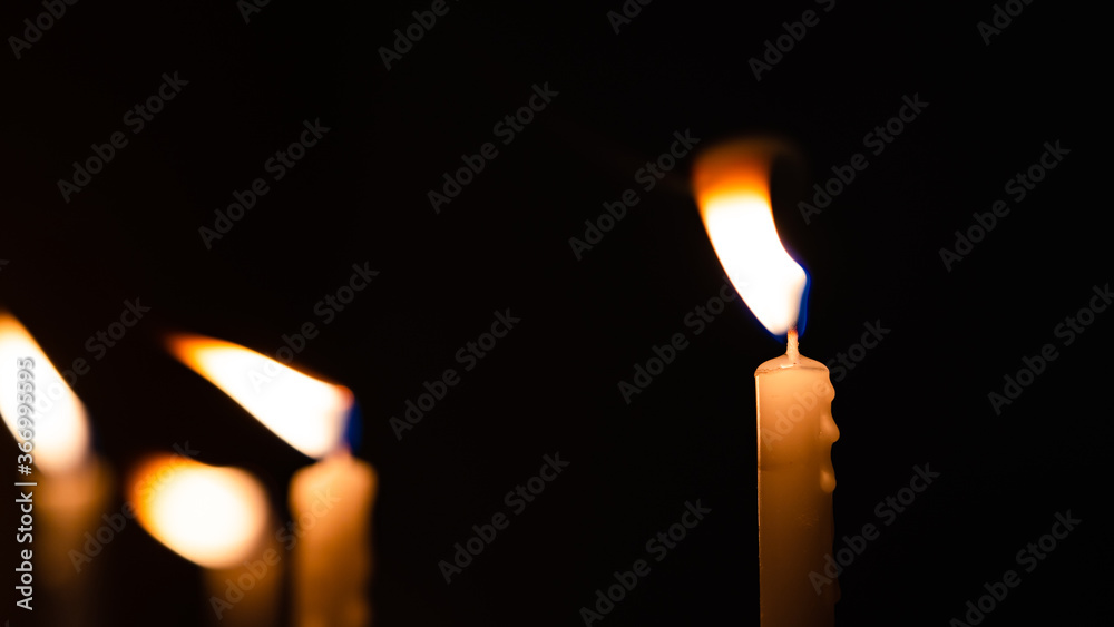 Close-up shots of yellow candles and lights on a black background with bokeh lights Close-up shots of yellow candles and lights on a black background with bokeh lights