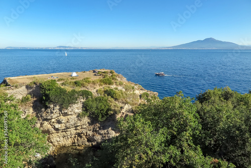 Stone where is the Regina Giovanna Bath well with the Mediterranean Sea and the Vesuvio volcano in the background, Sorrento commune, Naples province, Italy