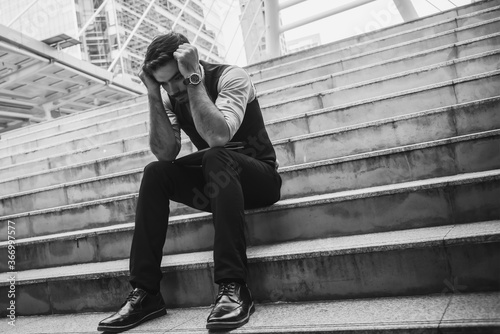 Fotografía Black and White images of Businessmen sitting on conreete stairs, being stressed