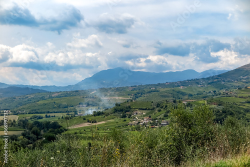 Valley with several farms and plantations and mountains in the background, Campania region, Benevento province, Italy