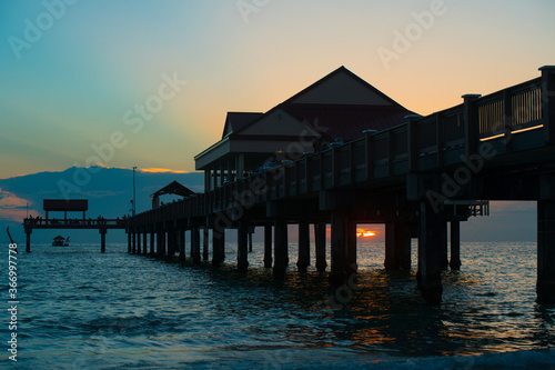 Long fishing pier. Ocean sunset. Summer vacation.
