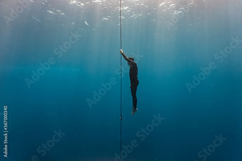 Free diver ascends to the surface by pulling the dive line