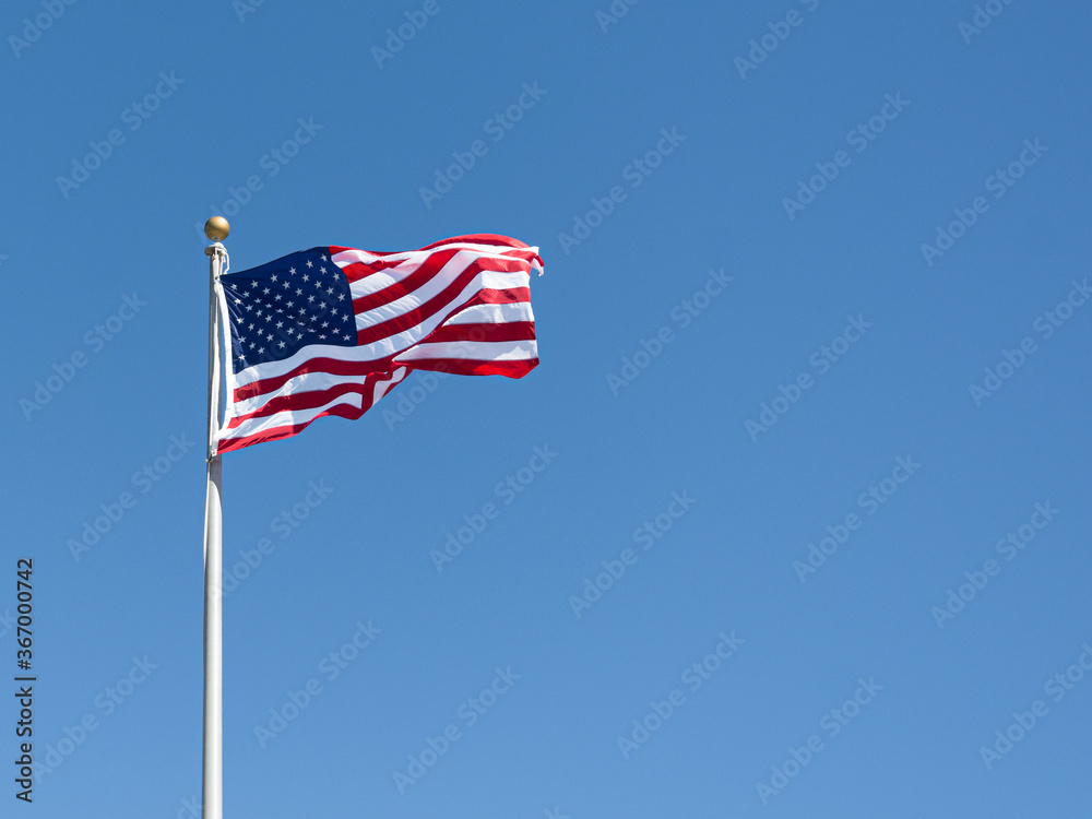 Flag of the USA Flying in a Clear Blue Sky Flag of the USA Flying in a Clear Blue Sky
