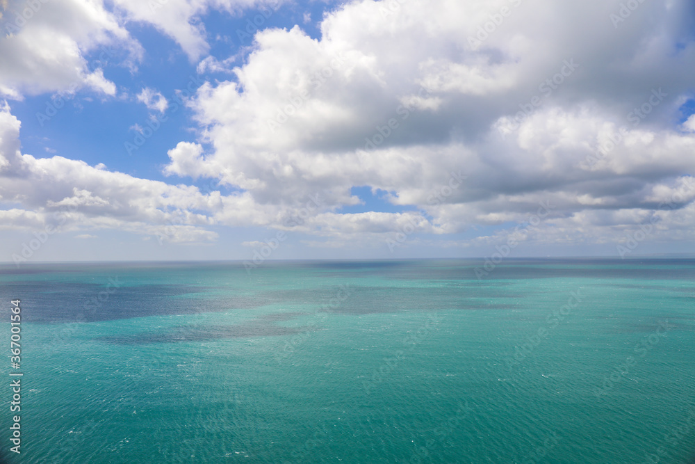 Ocean view with turquoise water and blue sky with clouds