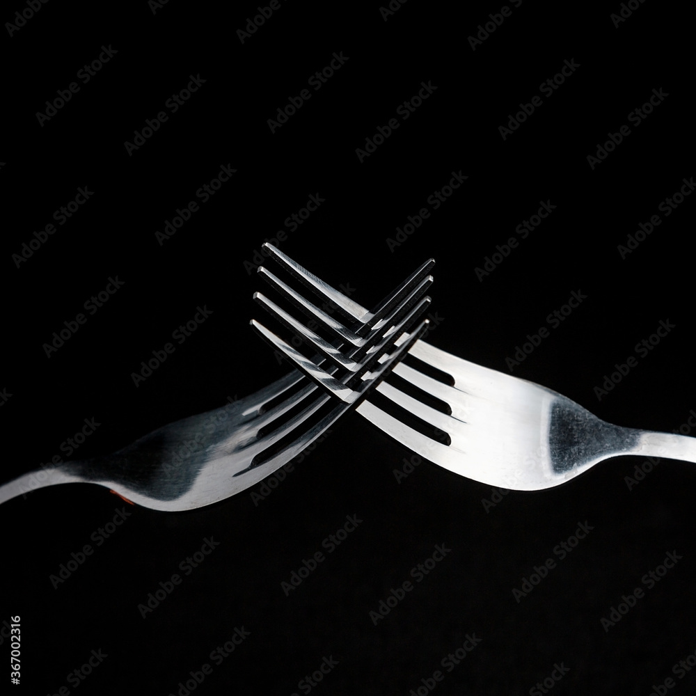 two forks crossed on a dark background. two forks crossed on a dark background.