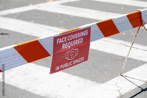 Face covering required warning signs for face masks on public streets during COVID 19 Coronavirus
