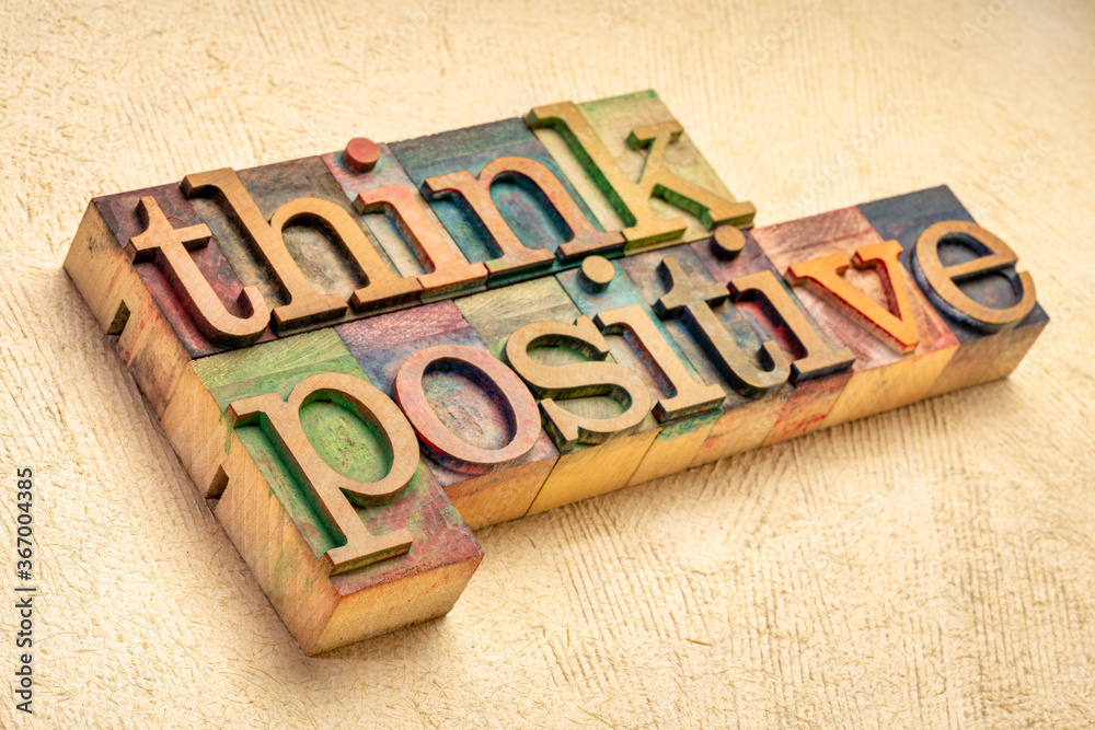 Think positive - word abstract in vintage letterpress wood type blocks against textured handmade paper, optimism, positivity and mindset concept - obrazy, fototapety, plakaty 