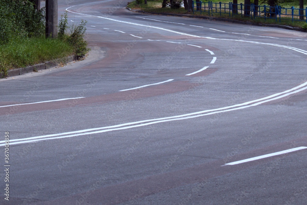 empty winding paved road with a marking of traffic lanes empty winding paved road with a marking of traffic lanes