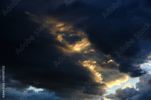 Storm clouds with breaking rays of sunlight.