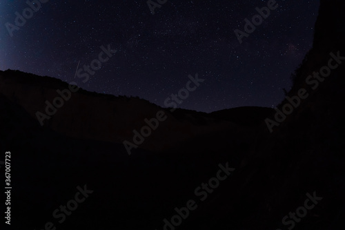 Night star sky with Milky way galaxy and canyon with mountains