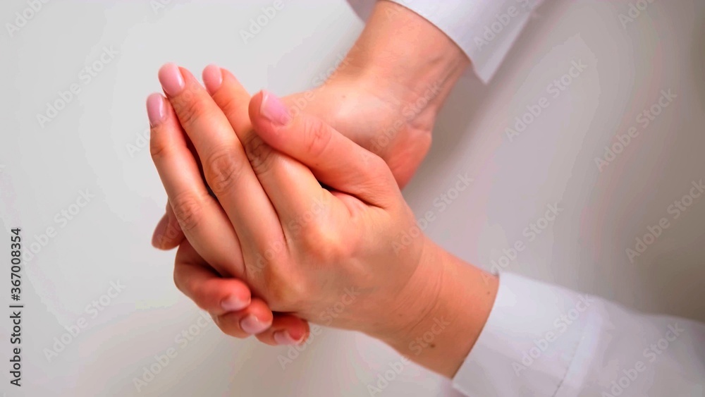 Fototapeta premium A close-up on a woman who is rubbing her hands