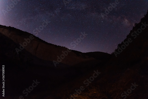 Night star sky with Milky way galaxy and canyon with mountains