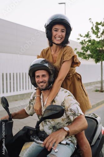 couple riding motorcycle, wife is sitting behind her husband