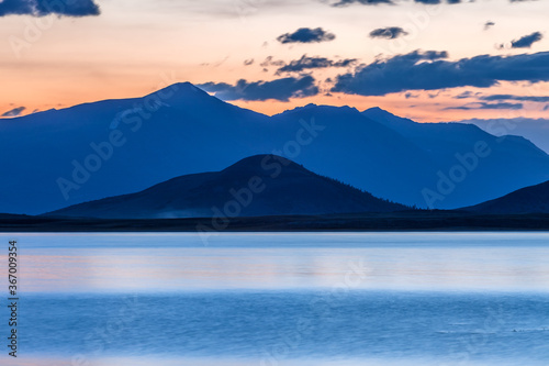 Mountain landscape at sunset. Outstanding view of the mountain ridges and clouds. Mountain Lake in Altai of Mongolia