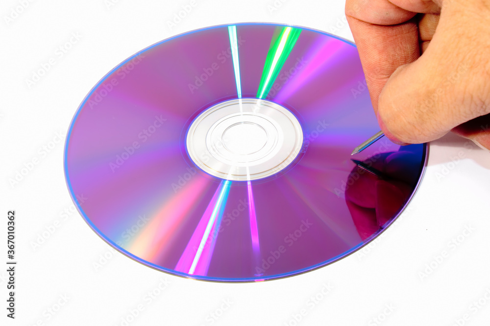  Bottom of a DVD with a nail ready to scratch it 