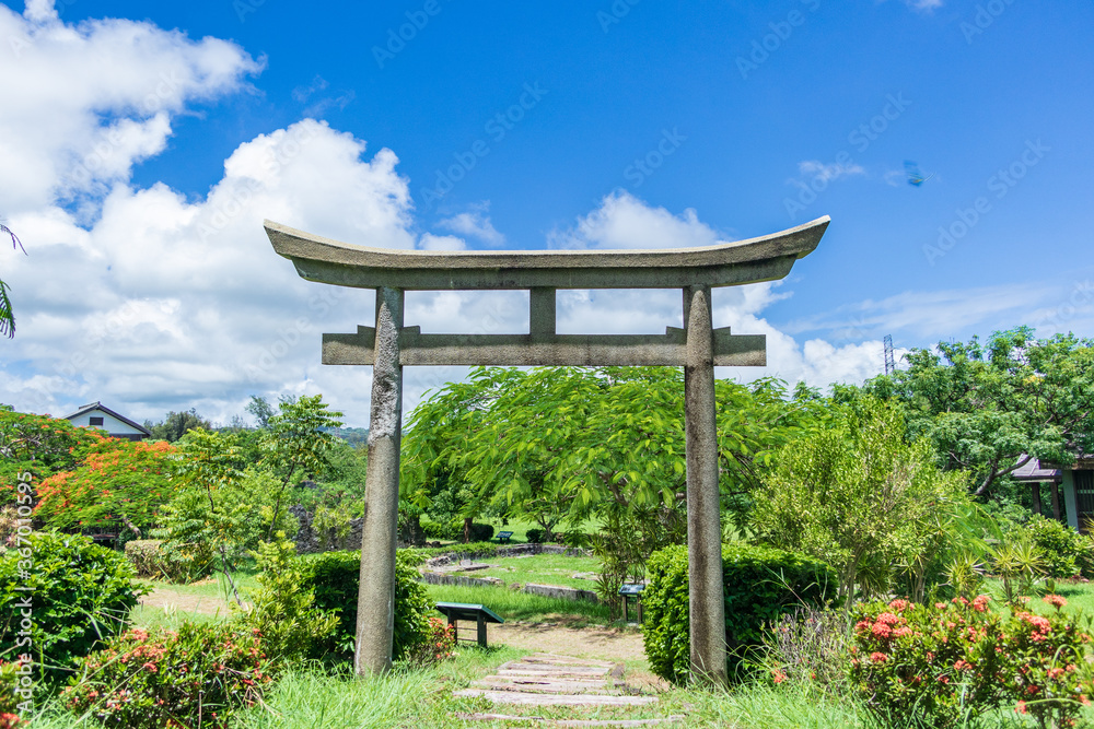 Ancient stone torii and beautiful poinciana in the Ancient stone torii and beautiful poinciana in the
