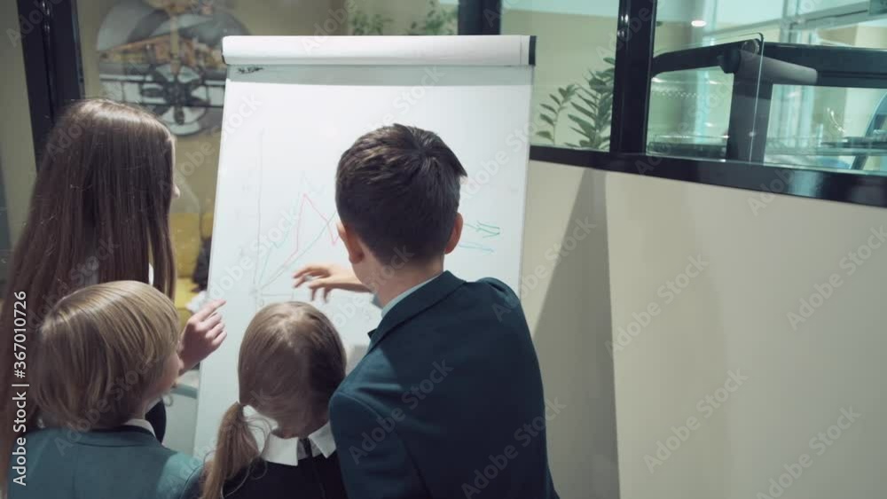 A group of people in the office draws a graph on the blackboard and discuss it. A group of people in the office draws a graph on the blackboard and discuss it.