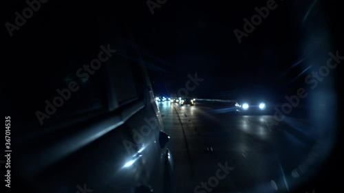 Back mirrow view night traffic chasing or run away , a lot of cars driving slowly with lights on