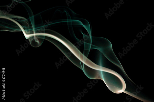 Real smoke on a dark background. Abstract wallpaper with color overlay. Mystical smoke. Isolated strict background. Semi-transparent smoke with smooth transitions of color. Magic forms