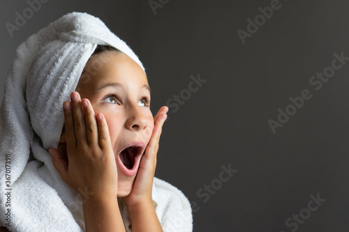adorable little girl happy smiling after spa bath on a white bath towel head