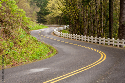 A winding section of the old Columbia River Highway near Multnomah Falls, Oregon.  Guard rail is the old wooden type.