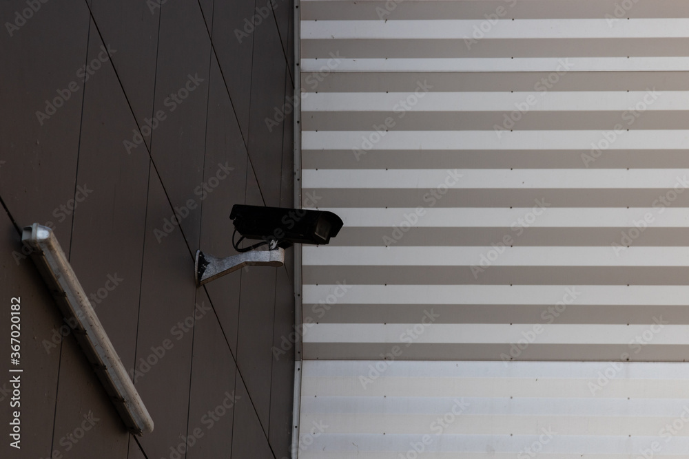 Surveillance camera on the outside wall of a building symbolizing state supervision Surveillance camera on the outside wall of a building symbolizing state supervision