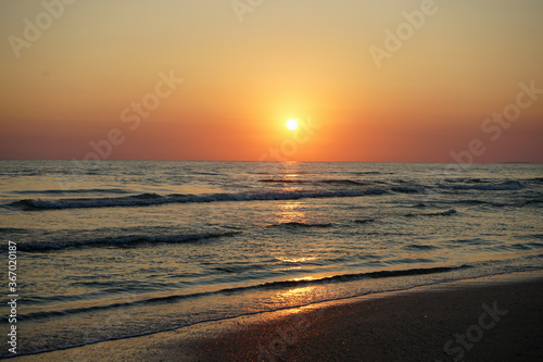red sunset on the beach with beautiful sea  waves and orange sky.