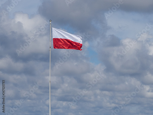 on flagpole the red and white flag of Poland is waving