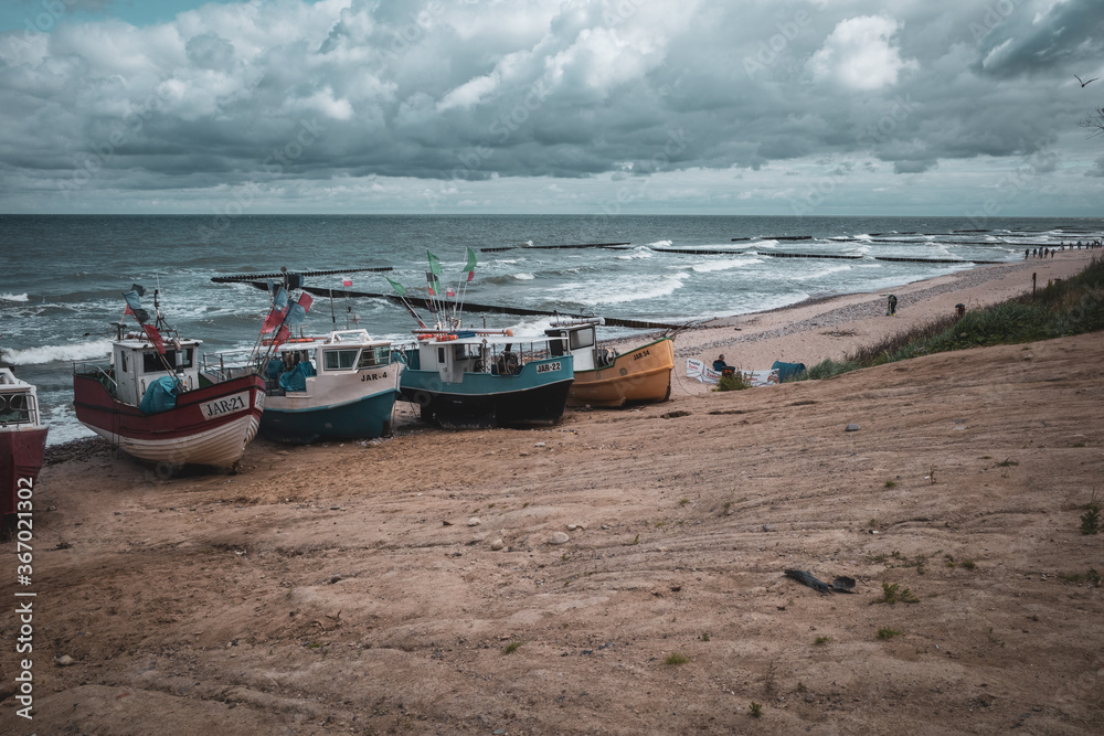 At Beach of Jaroslawiec in Poland fishing boats lie on the beach of the Baltic Sea At Beach of Jaroslawiec in Poland fishing boats lie on the beach of the Baltic Sea
