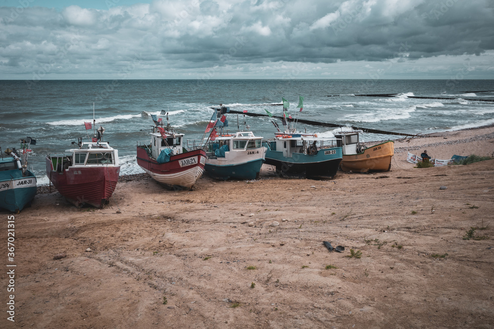 Fototapeta premium At Beach of Jaroslawiec in Poland fishing boats lie on the beach of the Baltic Sea