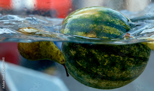 pear with watermelon floats on the surface of the water together with the pear