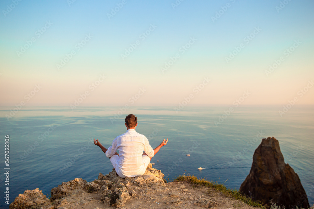 Man outdoor on edge of cliff seashore