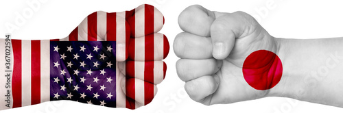 Fototapeta Naklejka Na Ścianę i Meble -  Two hands are clenched into fists and are located opposite each other. Hands painted in the colors of the flags of the countries. Japan vs USA