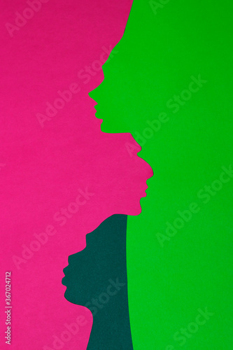 The paper profiles were cut out from pink, navy green and neon green paper. The vertical photo of handmade paper art was shot flat lay for your craft design.