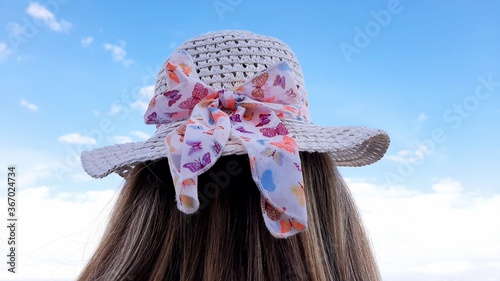 Girl waring a hat looking at the sky 