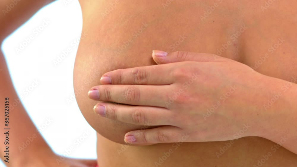 Woman with large breast doing breast examination and looking for signs of breast cancer. Woman with large breast doing breast examination and looking for signs of breast cancer.