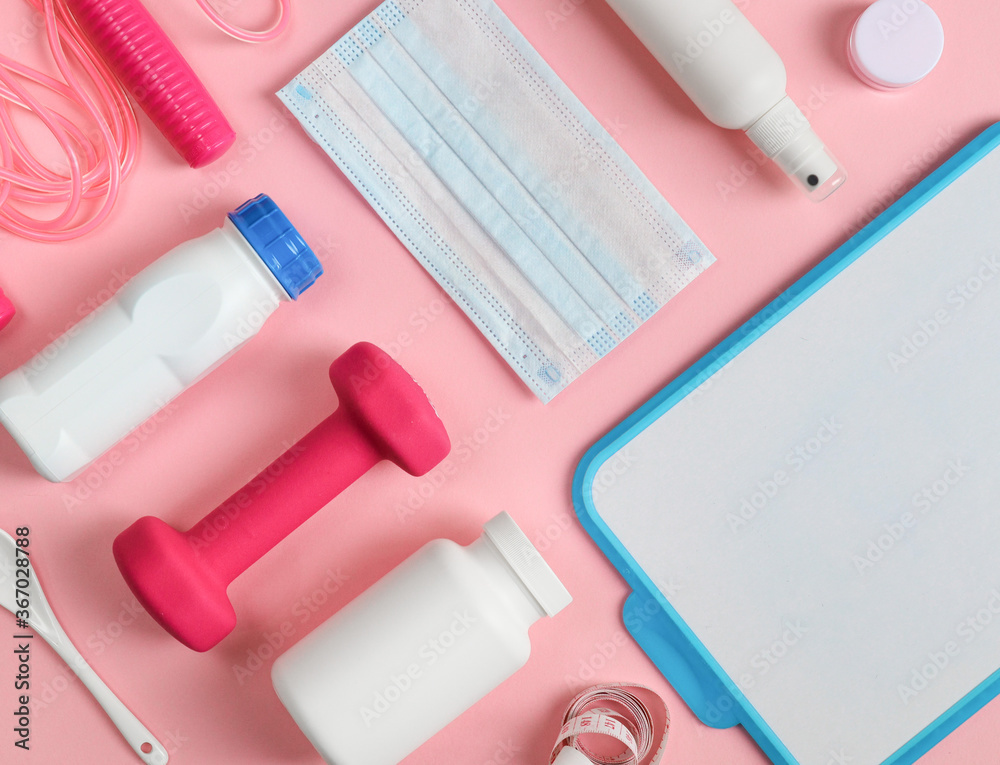 Sporting goods on a pink background.
Sports items: dumbbell, measuring tape, protein drink, skipping rope, disinfectant, mask and writing board lie on a pink background, top view close up. Sporting goods on a pink background.
Sports items: dumbbell, measuring tape, protein drink, skipping rope, disinfectant, mask and writing board lie on a pink background, top view close up.