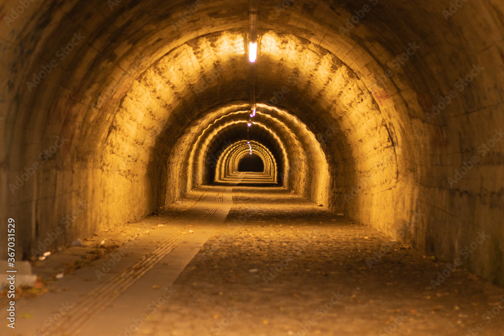 pedestrian tunnel illuminated by yellow lamp pedestrian tunnel illuminated by yellow lamp