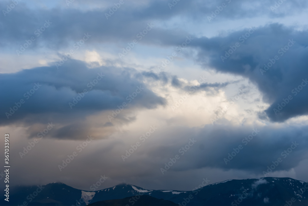 mountain ridge silhouette in a mist and dense clouds, outdoor natural background