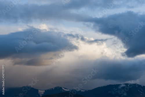 mountain ridge silhouette in a mist and dense clouds, outdoor natural background