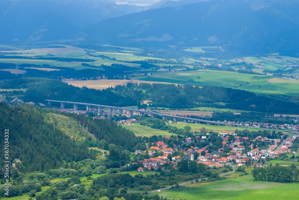 view to a small european town in a green mountain valley