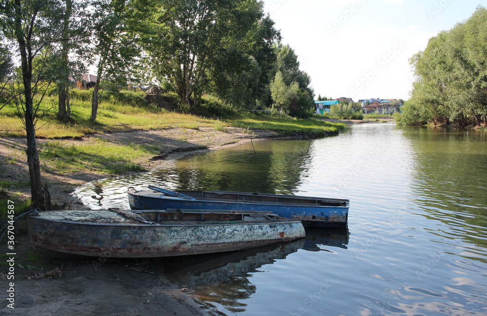 Fototapeta premium old boats on the river Bank in the summer in a Siberian village