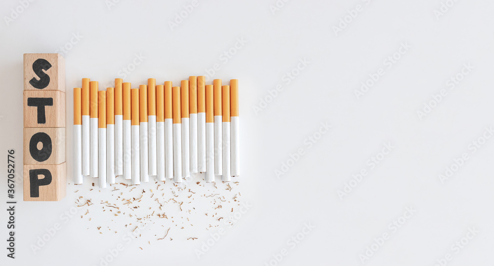 Overhead view of stop text wood cube from cigarette, Stop smoking initiative cubic wooded concept of breaking cigarettes,Top view no smoke text in wood block on white background, World no tobacco day. Overhead view of stop text wood cube from cigarette, Stop smoking initiative cubic wooded concept of breaking cigarettes,Top view no smoke text in wood block on white background, World no tobacco day.