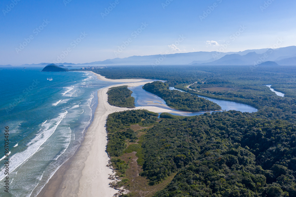Foto aérea do encontro da água do rio com o mar. Praia de Guaratuba e Rio Itaguaré. Curvas e formas do rio. Linda imagem da junção do rio com a praia em meio a natureza preservada. Foto aérea do encontro da água do rio com o mar. Praia de Guaratuba e Rio Itaguaré. Curvas e formas do rio. Linda imagem da junção do rio com a praia em meio a natureza preservada.