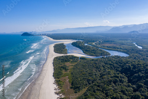 Foto aérea do encontro da água do rio com o mar. Praia de Guaratuba e Rio Itaguaré. Curvas e formas do rio. Linda imagem da junção do rio com a praia em meio a natureza preservada. 