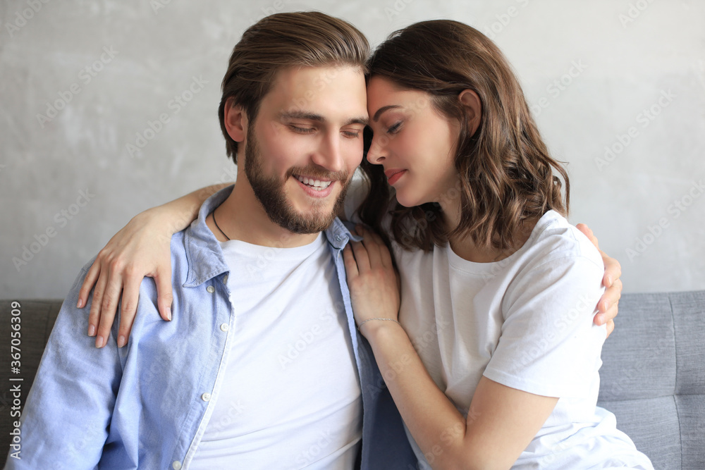 Young loving couple relaxing on sofa together. Woman and man embrace enjoy company of each other sitting on couch holding hands having romantic date. Young loving couple relaxing on sofa together. Woman and man embrace enjoy company of each other sitting on couch holding hands having romantic date.