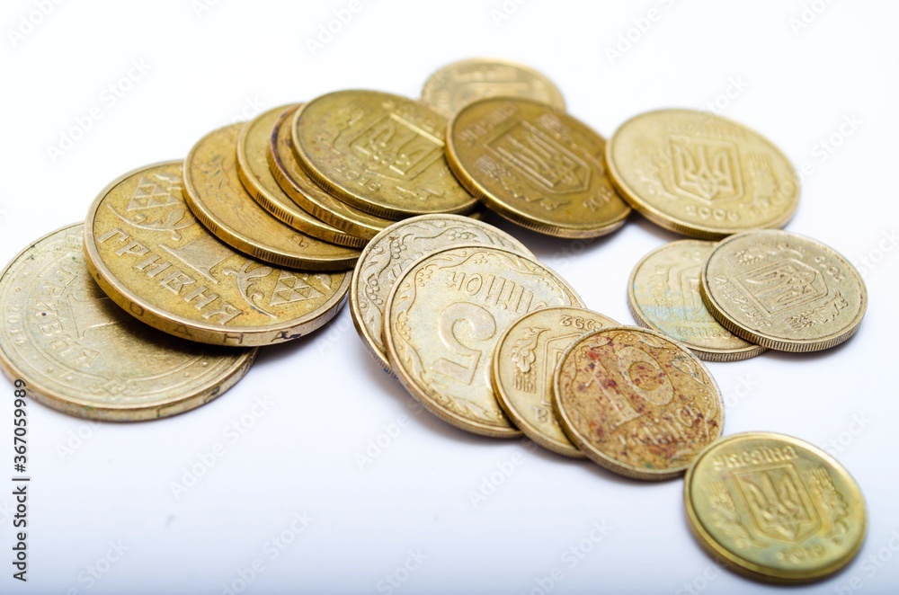 Ukrainian coins on a white background in close-up. Coins in a heap close-up, in the form of a falling pyramid, in a man's hand Ukrainian coins on a white background in close-up. Coins in a heap close-up, in the form of a falling pyramid, in a man's hand